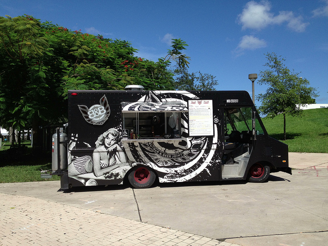 parked black food truck with a woman